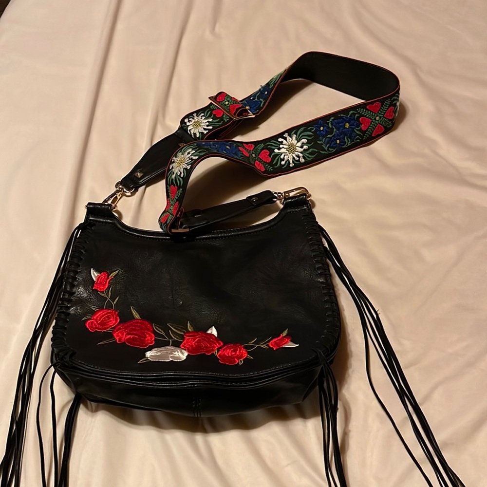 Black crossbody bag with tapestry design.